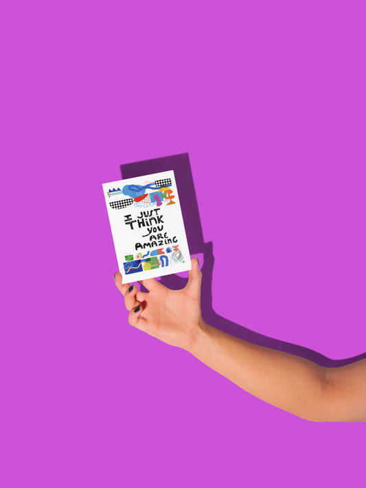 Hand holding a card with colorful text and graphics against a purple background