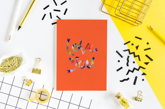 greeting card with an orange background with colorful text that reads love you