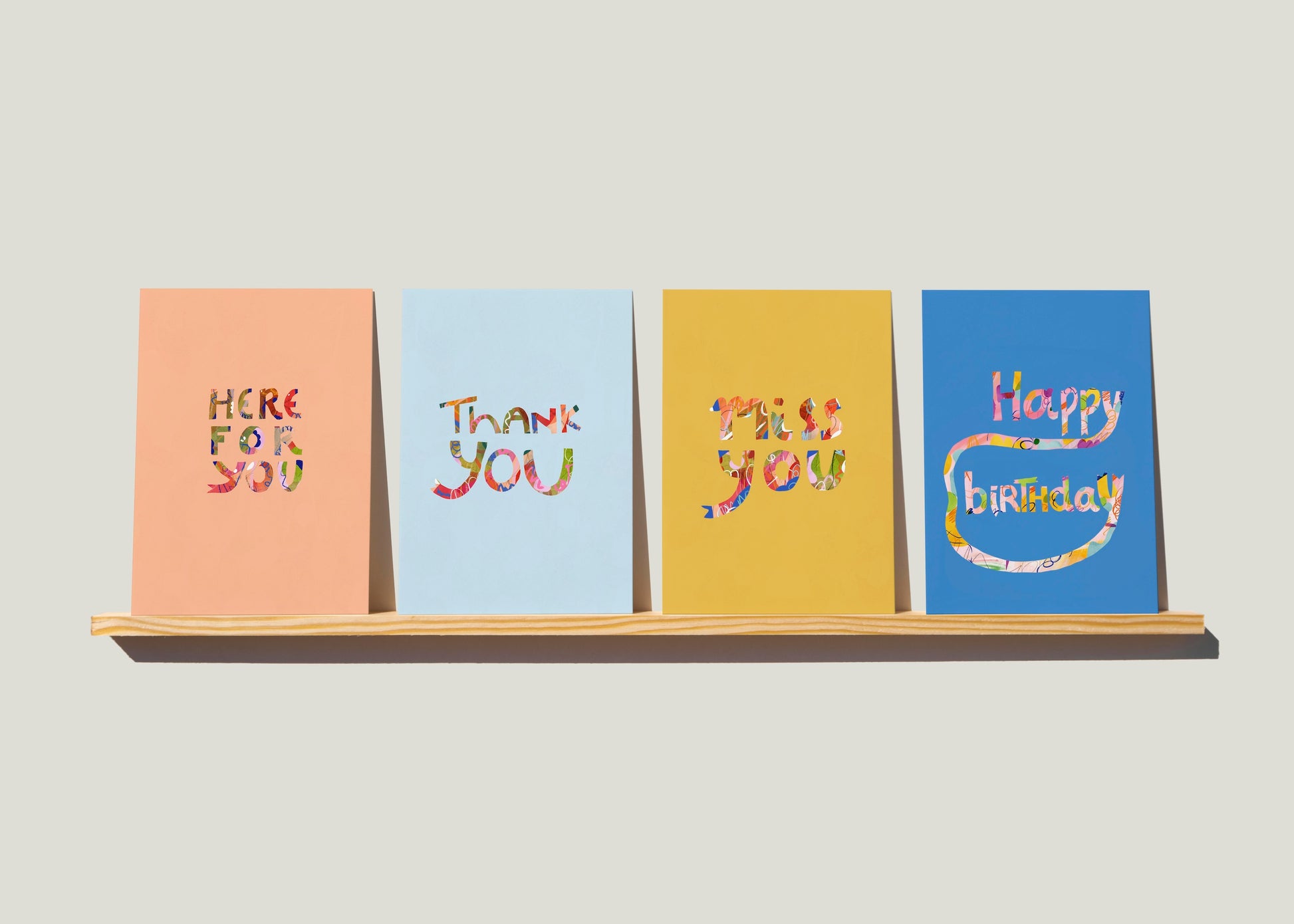 set of four greeting cards with assorted text and solid colored background