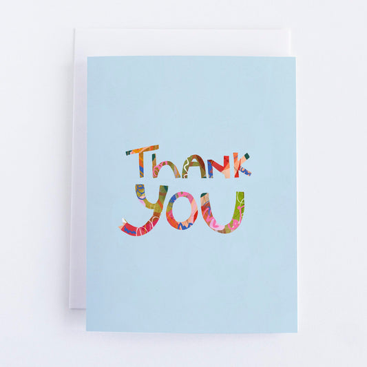 A blue thank you greeting card with a colorful 'Thank You' text printed on the front.