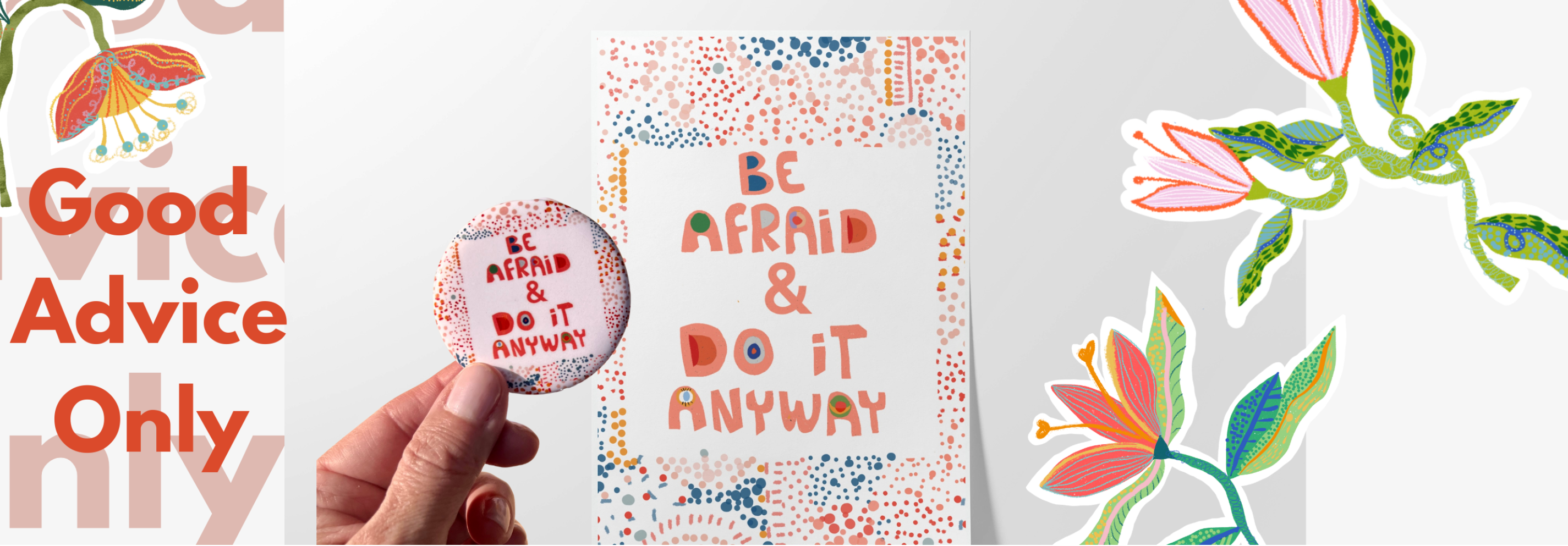 Hand holding a button with 'Be Afraid & Do It Anyway' text, next to a printed card with the same quote, on a floral background.