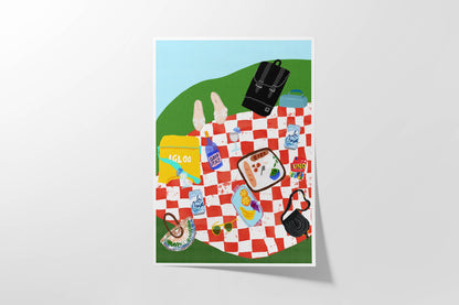 Vibrant art print of a red checkered picnic blanket with an Igloo cooler, Uno cards, wine, and fruit. Bold summer-themed wall decor.