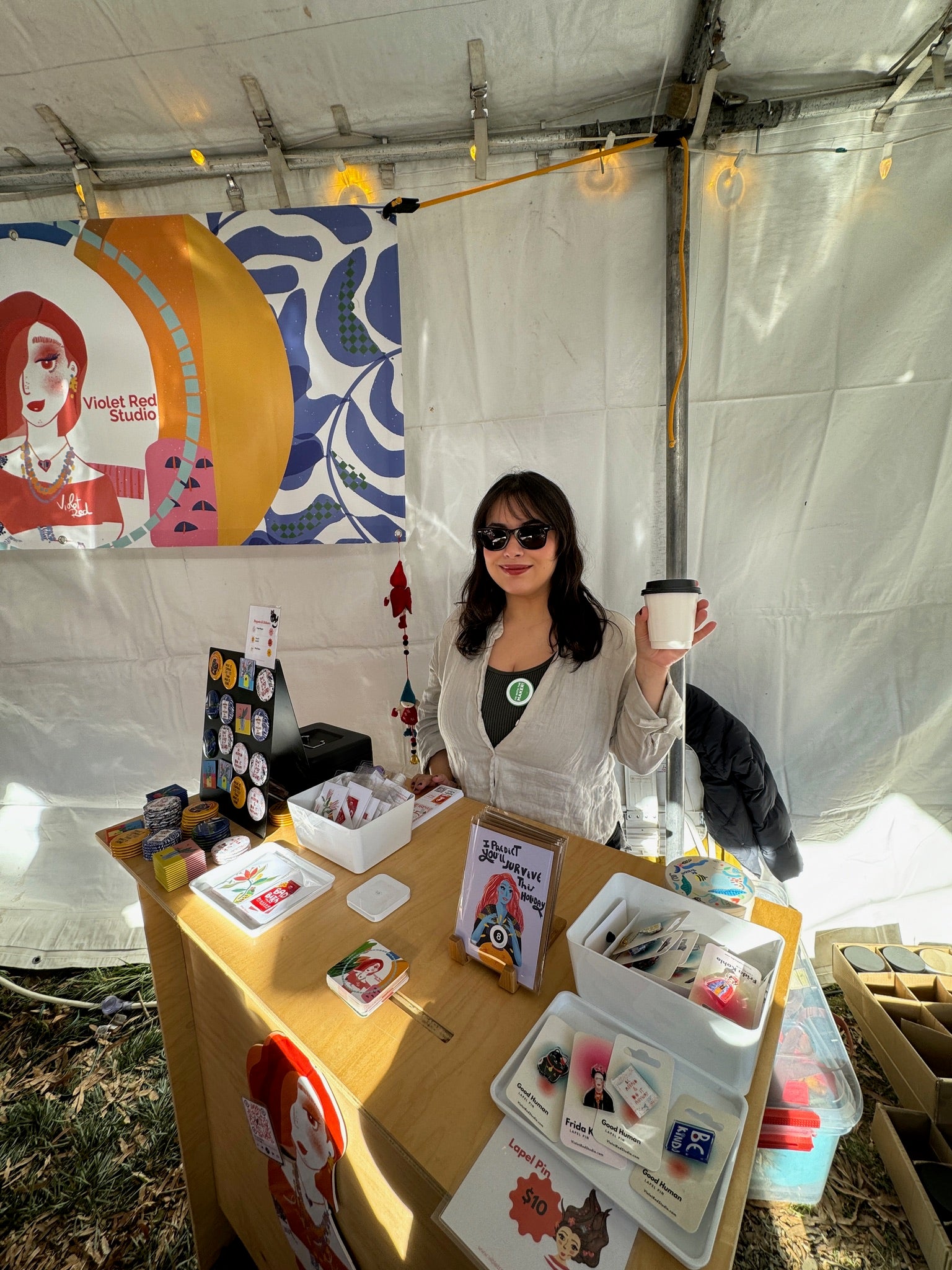 woman at faire booth holding a cup of coffee at check out