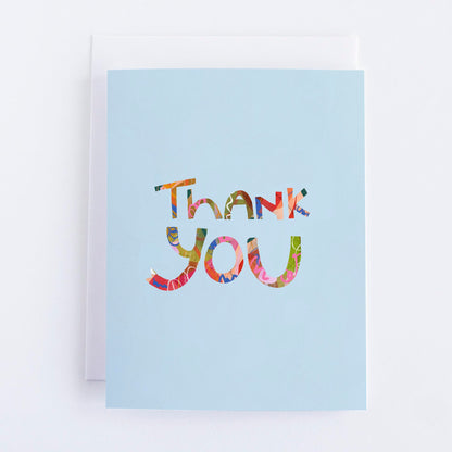 A blue thank you greeting card with a colorful 'Thank You' text printed on the front.